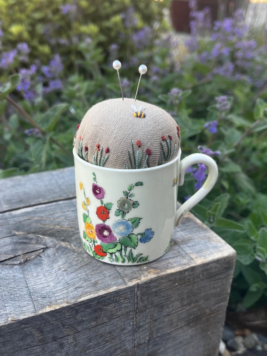 Pincushion in a vintage coffee cup with hollyhocks