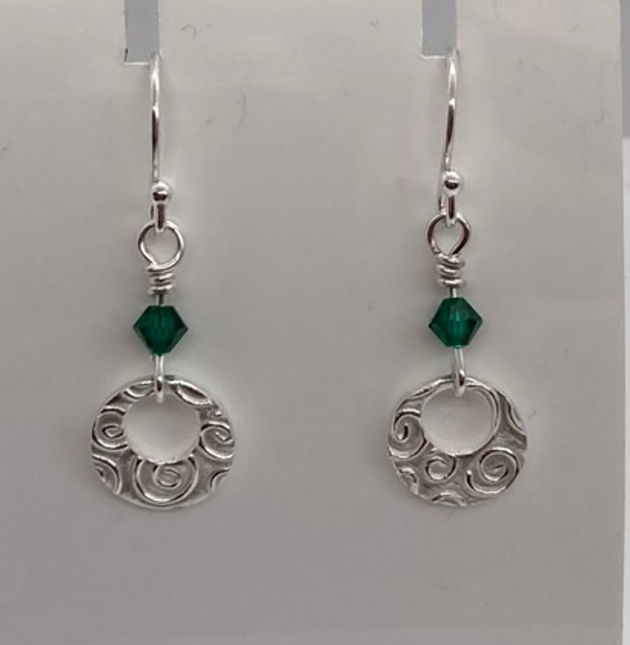 Circular, pure silver earrings with swirly, pattern and green Swarovski crystals