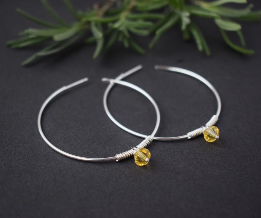 Large silver hoop earrings with yellow Swarovski crystal charm