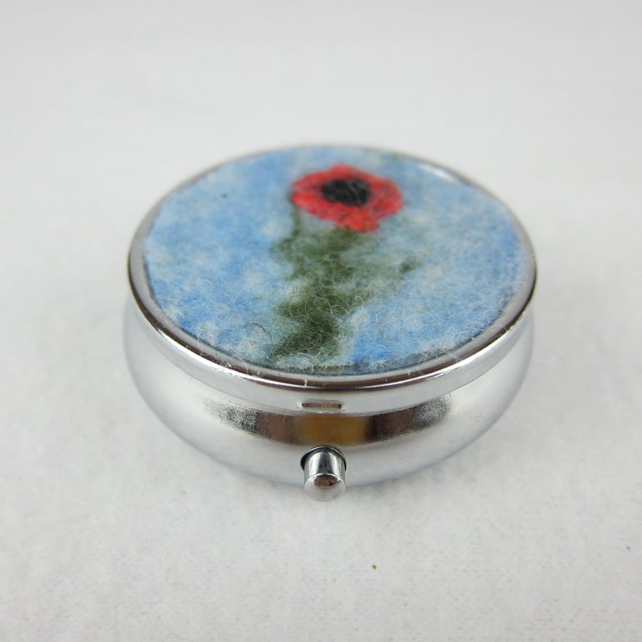 Round silver tone pill box with felted poppy design