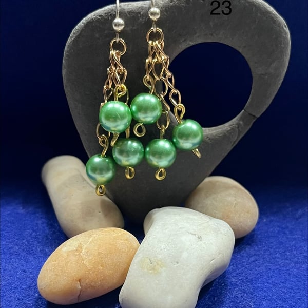 Beautiful dangling earrings on gold coloured chain with green beads.