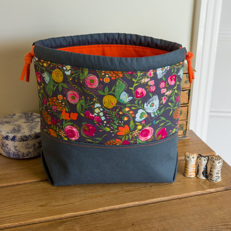 Drawstring project bag made with bright floral print in grey and orange