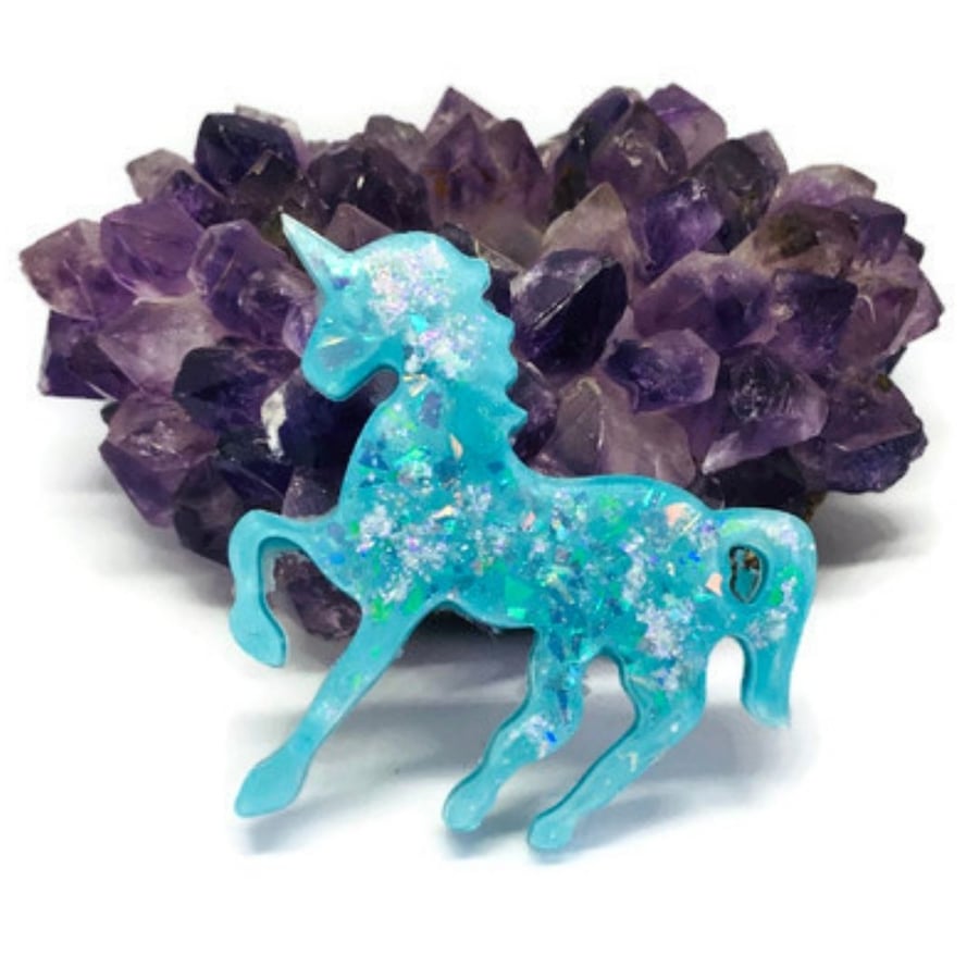 Turquoise blue unicorn sparkly statement pendant on black cord necklace.