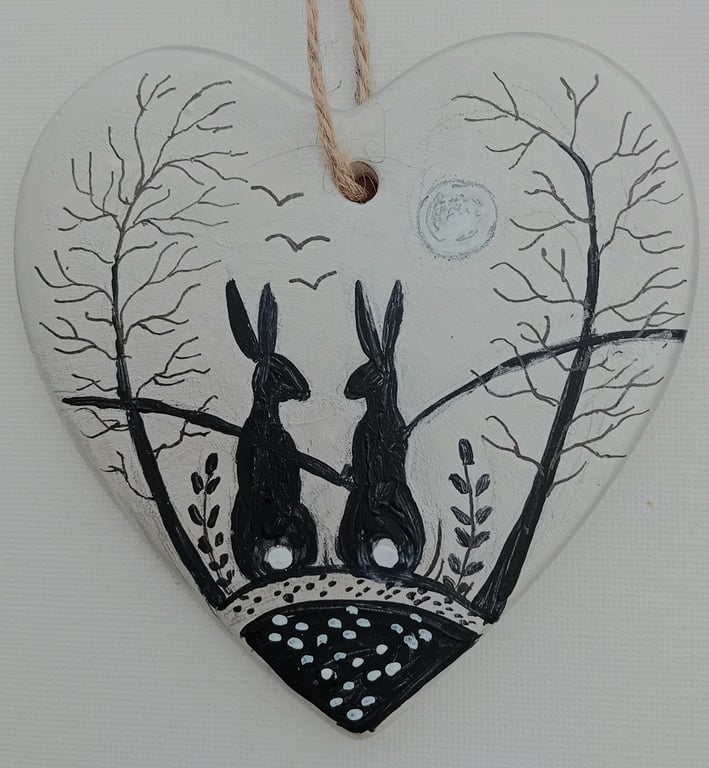 Silver black hares on a ceramic heart  