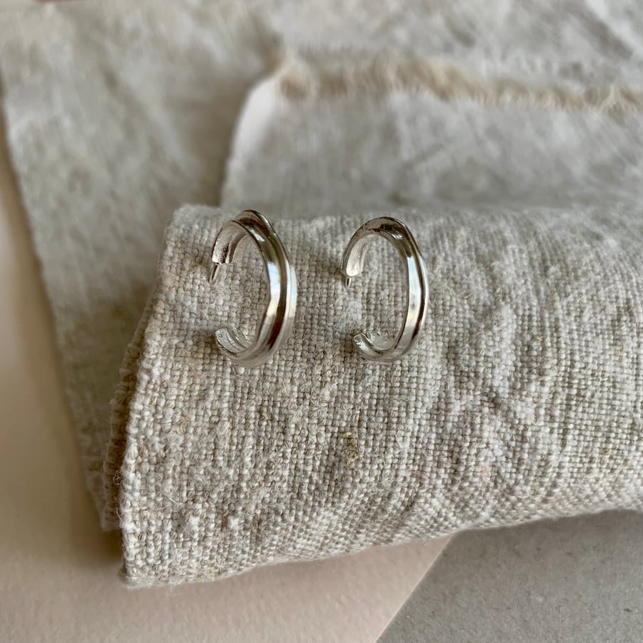 Small organic ridged textured silver hoop earrings.