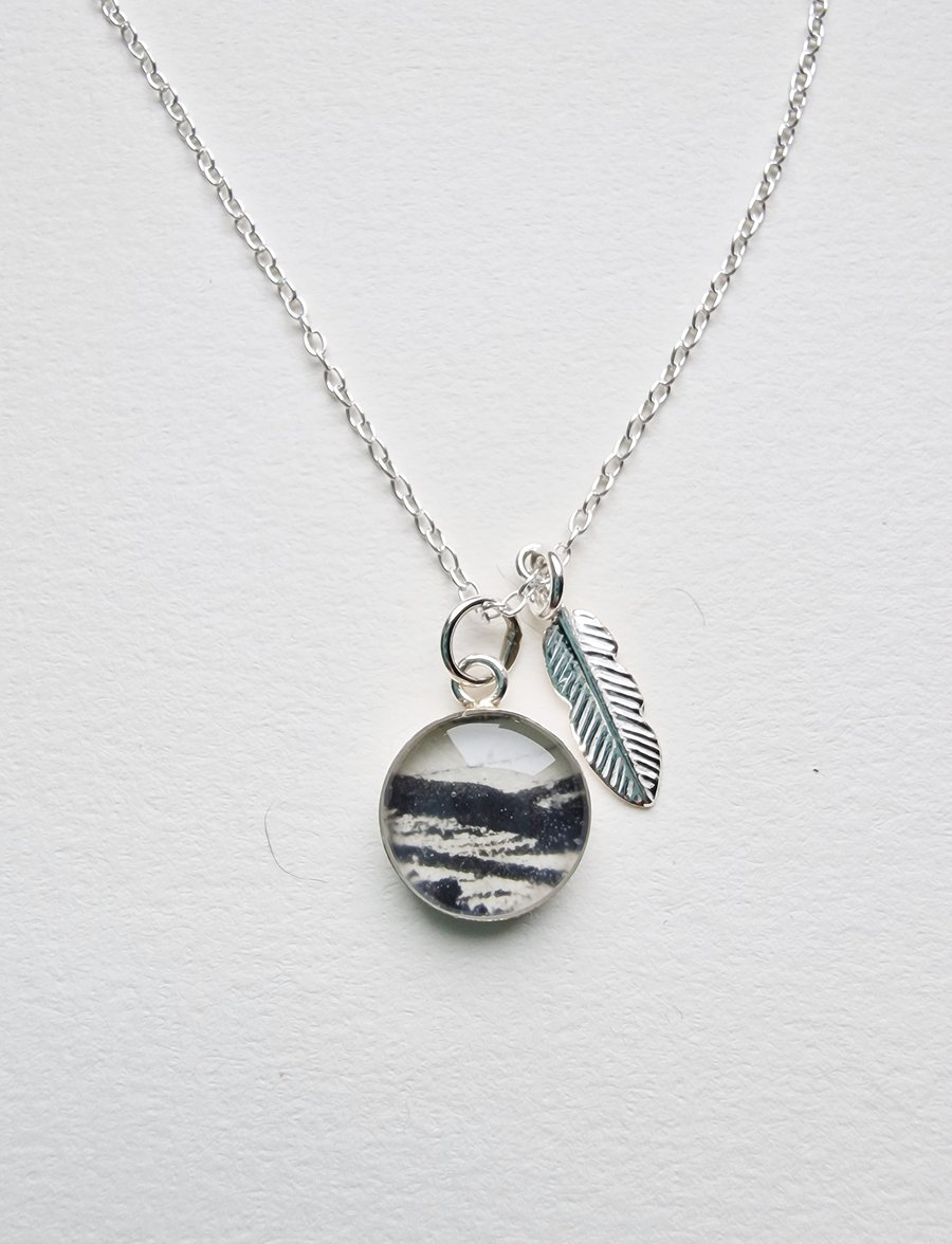 Beautiful little sterling silver and resin pendant with silver feather charm.