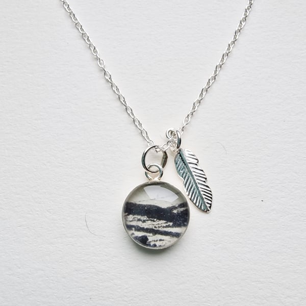 Beautiful little sterling silver and resin pendant with silver feather charm.