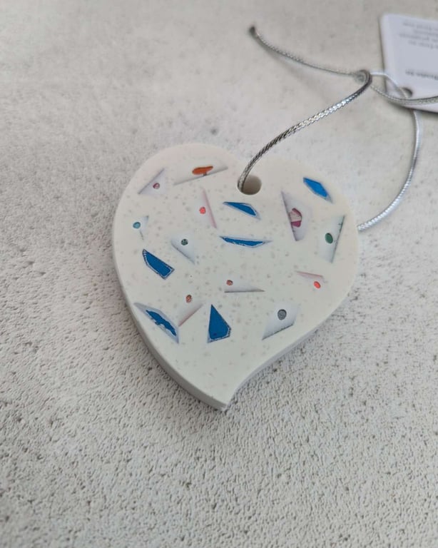 A handmade jesmonite heart filled with multicoloured hand dyed aluminium pieces