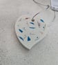 A handmade jesmonite heart filled with multicoloured hand dyed aluminium pieces