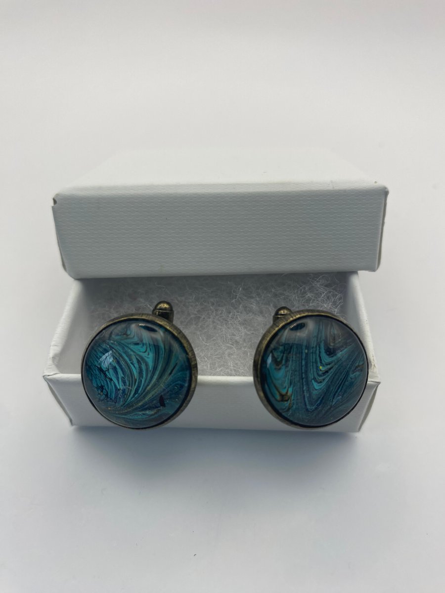 Pair of cuff links with turquoise, black and gold pigments 