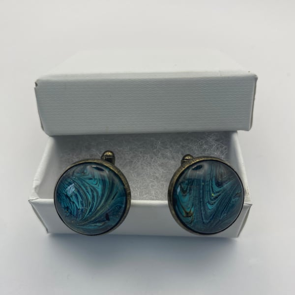 Pair of cuff links with turquoise, black and gold pigments 