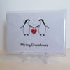 Merry Christmas card with two penguins and a red heart button