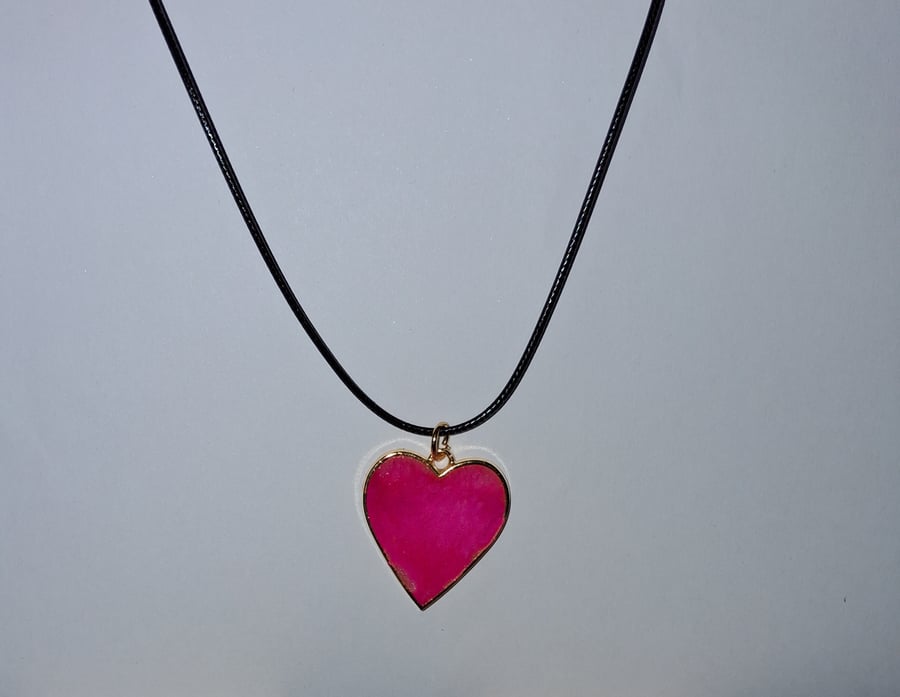 Handmade resin pink shimmer heart pendant on  black waxed cord