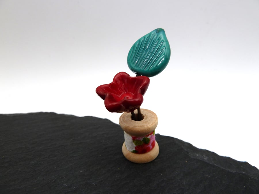 small glass bobbin, red flower