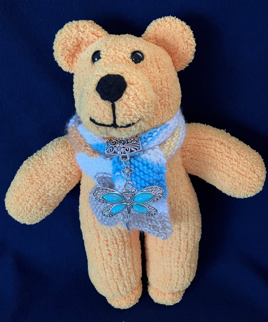 Golden Yellow Bear wearing a scarf and a dragonfly scarf bail 
