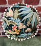 Round feature cushion in vintage leafy linen with pompoms - Image 6