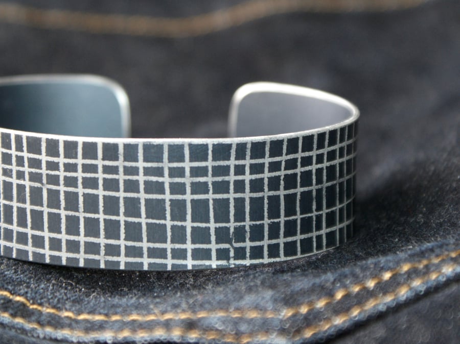 Dark grey criss cross aluminium cuff