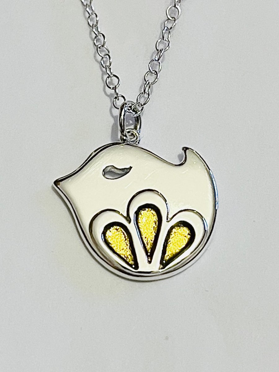 Sterling silver bird pendant with flower motif and gold enamel detail