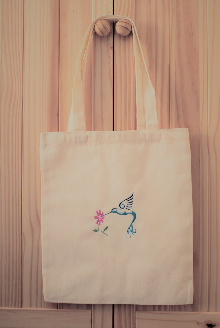 Humming bird machine embroidered on a cream tote bag