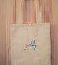Humming bird machine embroidered on a cream tote bag