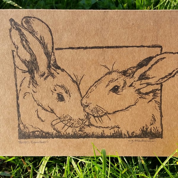 Hand printed signed linocut card "two's company" of 2 rabbits.