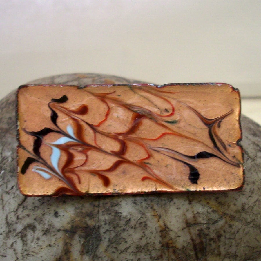 brooch - rectangular: scrolled red, brown, pale blue and black over clear enamel