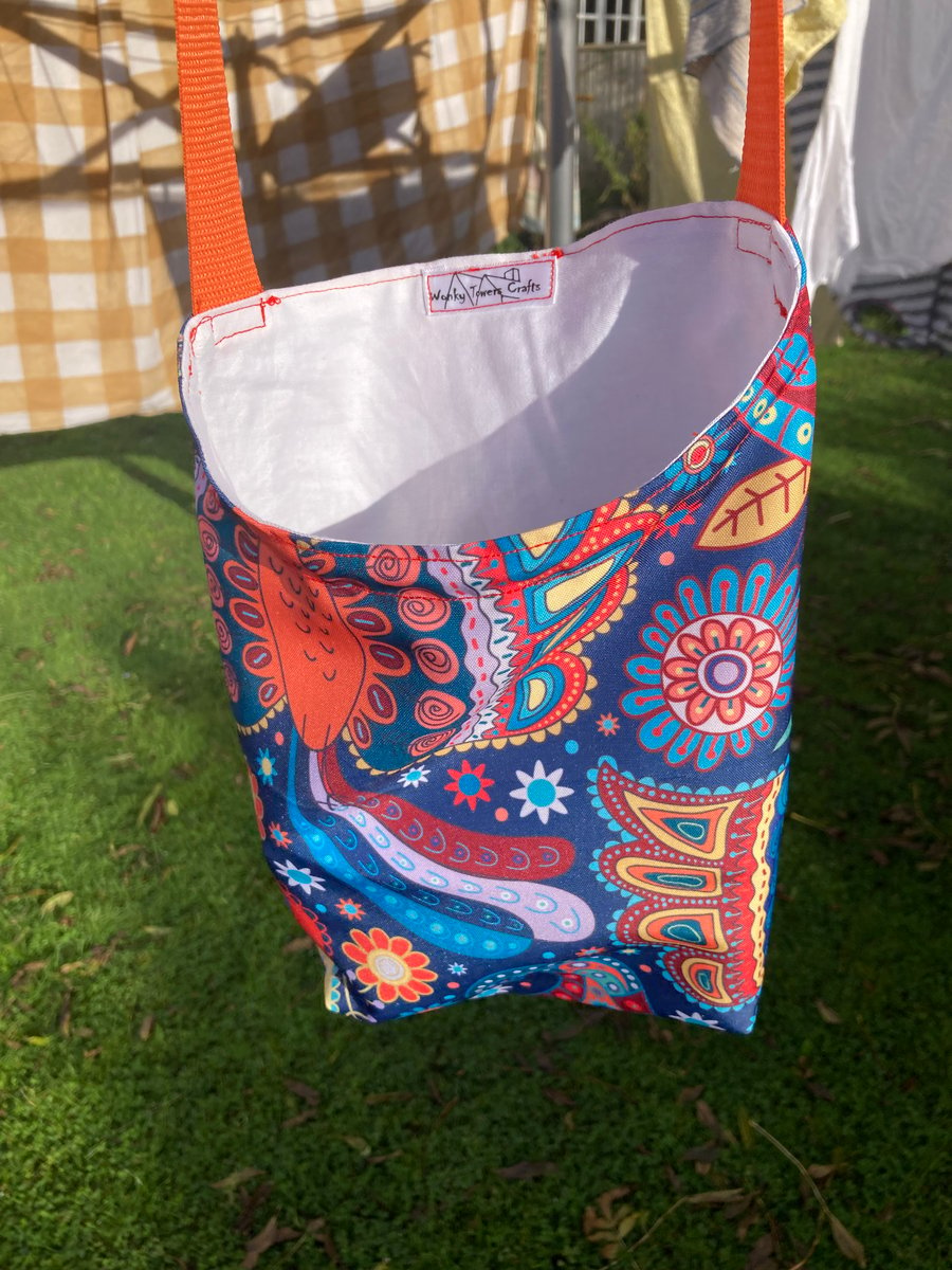 Shower-proof peg bag with orange strap. Bright ethnic design