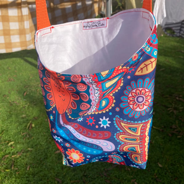 Shower-proof peg bag with orange strap. Bright ethnic design