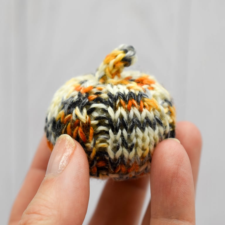 Hand knitted mini pumpkin pin cushion variegated cream, oranage and black