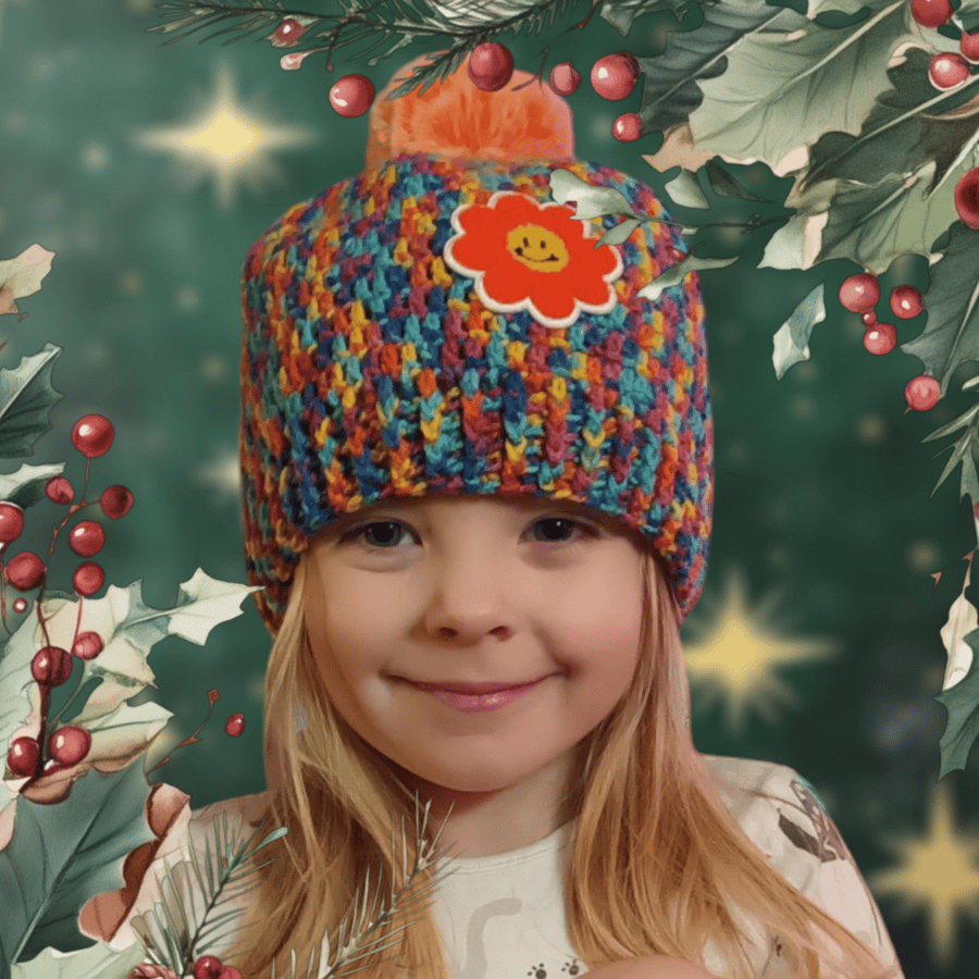 Colourful crochet pom pom hat with flower applique, 3-10 years.