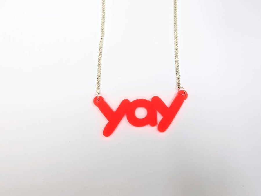 yay necklace on neon pink translucent acrylic with silver plated chain statement