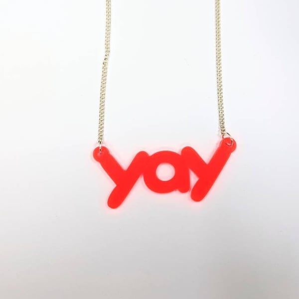 yay necklace on neon pink translucent acrylic with silver plated chain statement