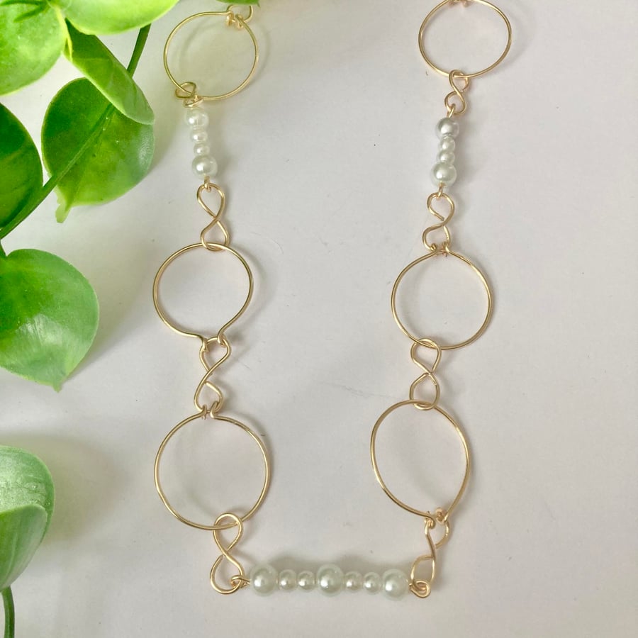 Gold Necklace Featuring White Glossy Glass Pearls in a Ring Design 18”