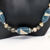 Blue and beige necklace made of paper beads with earth coloured separators