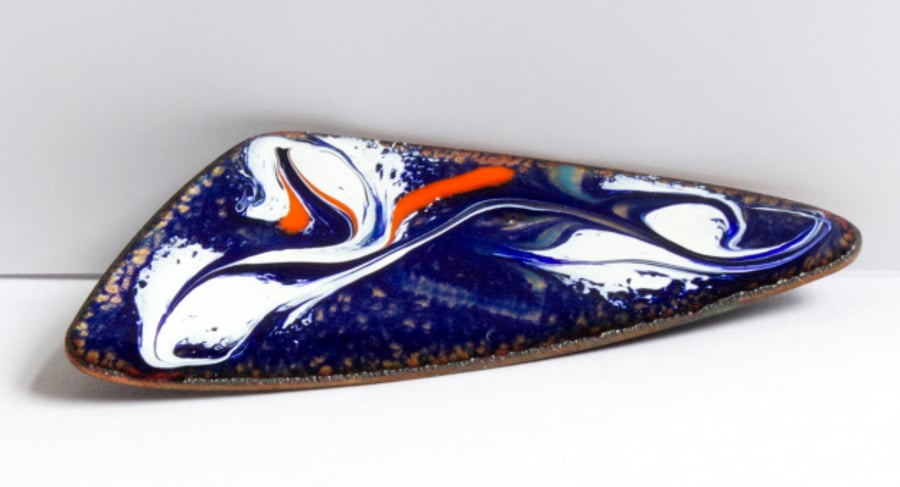 white and red scrolled over blue - triangular brooch