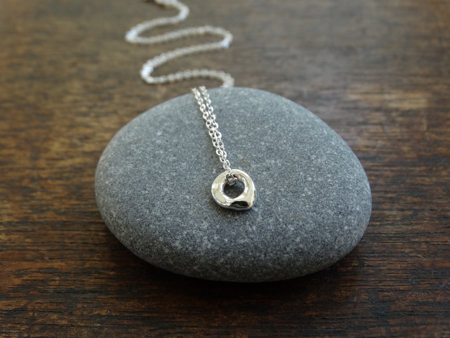 Tiny hagstone charm pendant - molten recycled silver