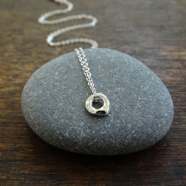 Tiny hagstone charm pendant - molten recycled silver