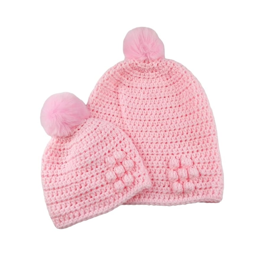 Matching ladies and baby pink crocheted hats with detachable faux fur pompoms 