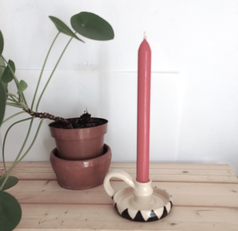 Ceramic black and white candleholder with handle.
