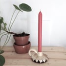 Ceramic black and white candleholder with handle.