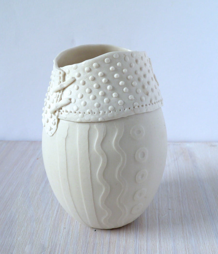 A delicate porcelain vase with resist and impressed decoration