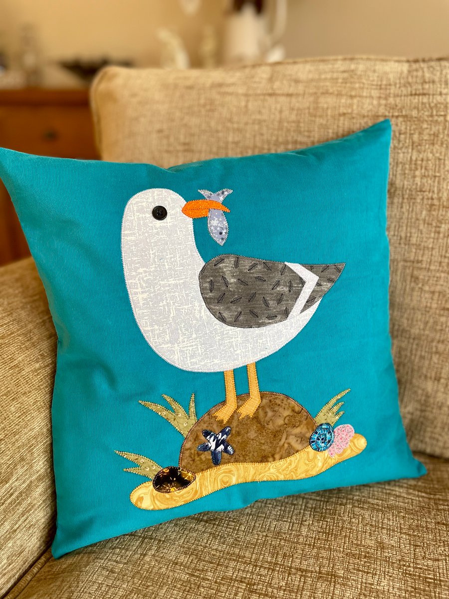 Cheeky seagull sitting on a rock appliqué cushion cover