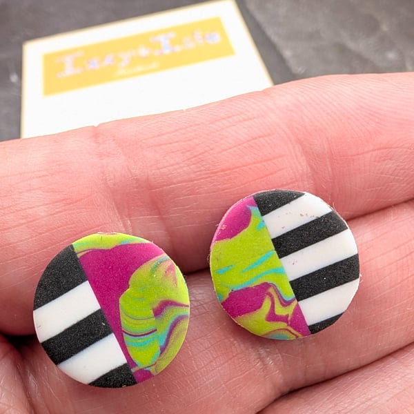 Stud earrings featuring monochrome strips and hot pink marble effect