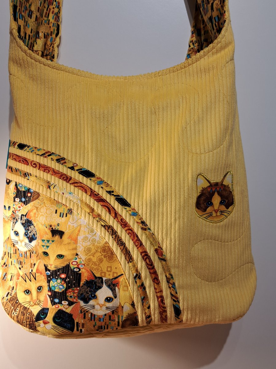 Yellow hobo style bag with golden cats