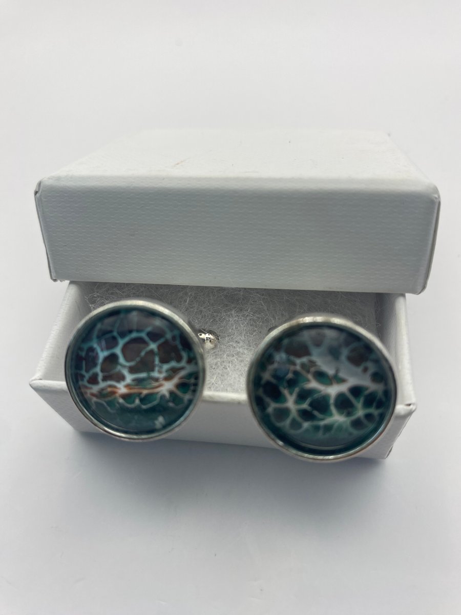 Pair of cuff links with pale blue green and brown gold pigments 