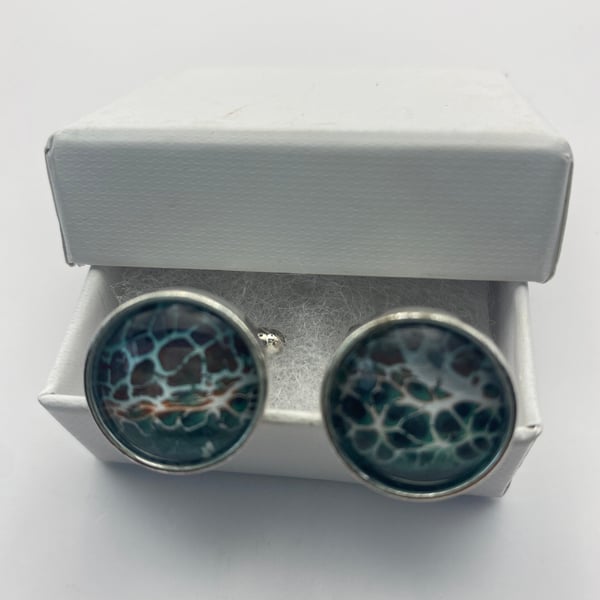 Pair of cuff links with pale blue green and brown gold pigments 