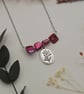 Pink mother of pearl beaded necklace with silver floral charm