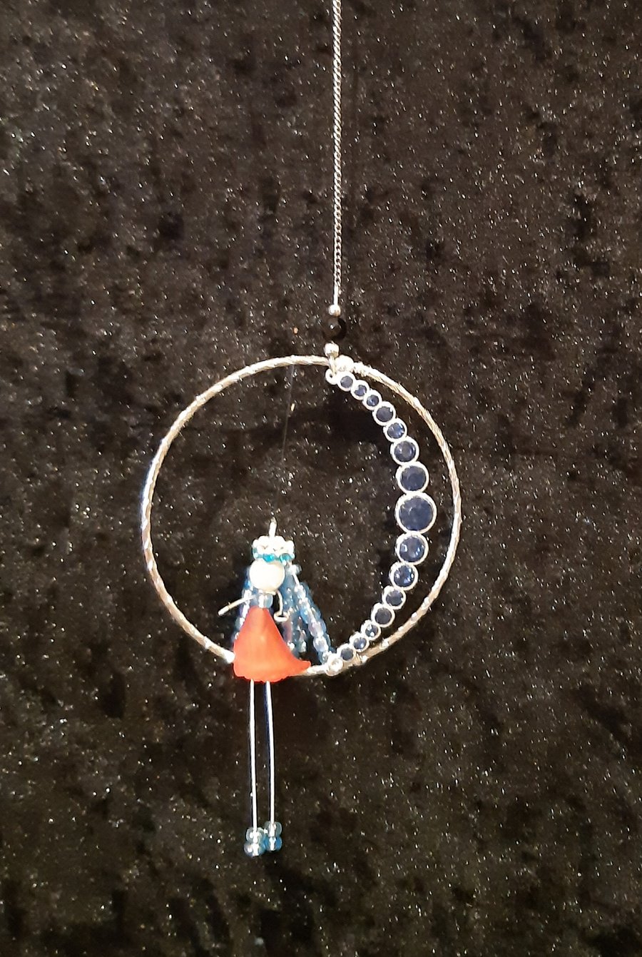 Angel sitting on the moon within a bangle.