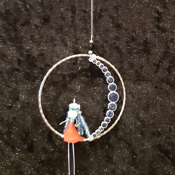 Angel sitting on the moon within a bangle.