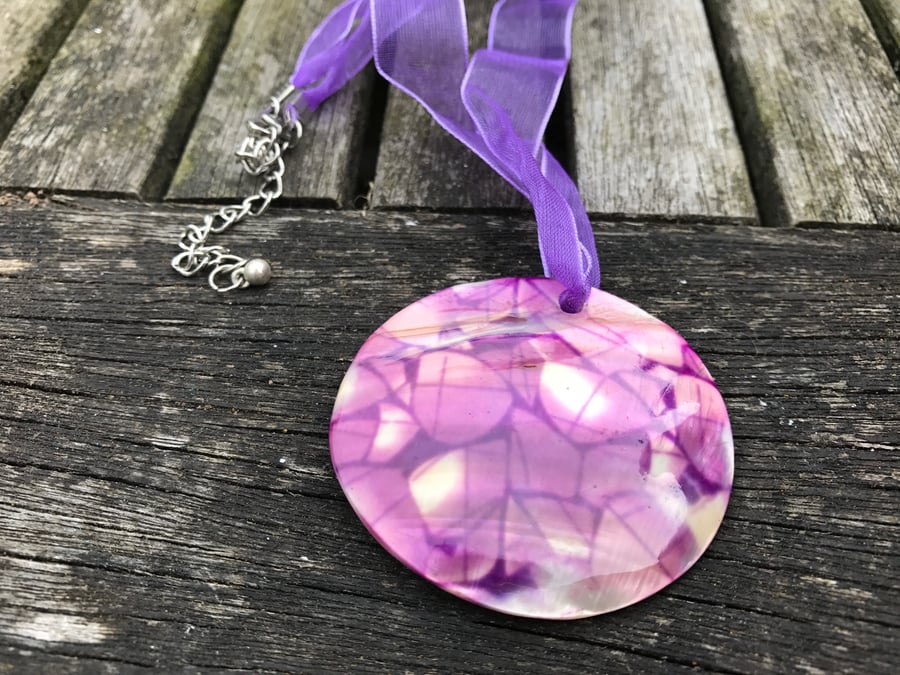 Purple patterned shell on purple ribbon